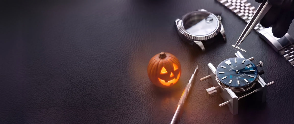 Assemblage à la main d'une Classic Date Chrono Mod, de nuit, à côté d'une citrouille d'Halloween